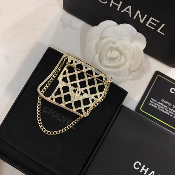 BAG SHAPED BROOCH IN GOLD METAL WITH BLACK CRYSTAL